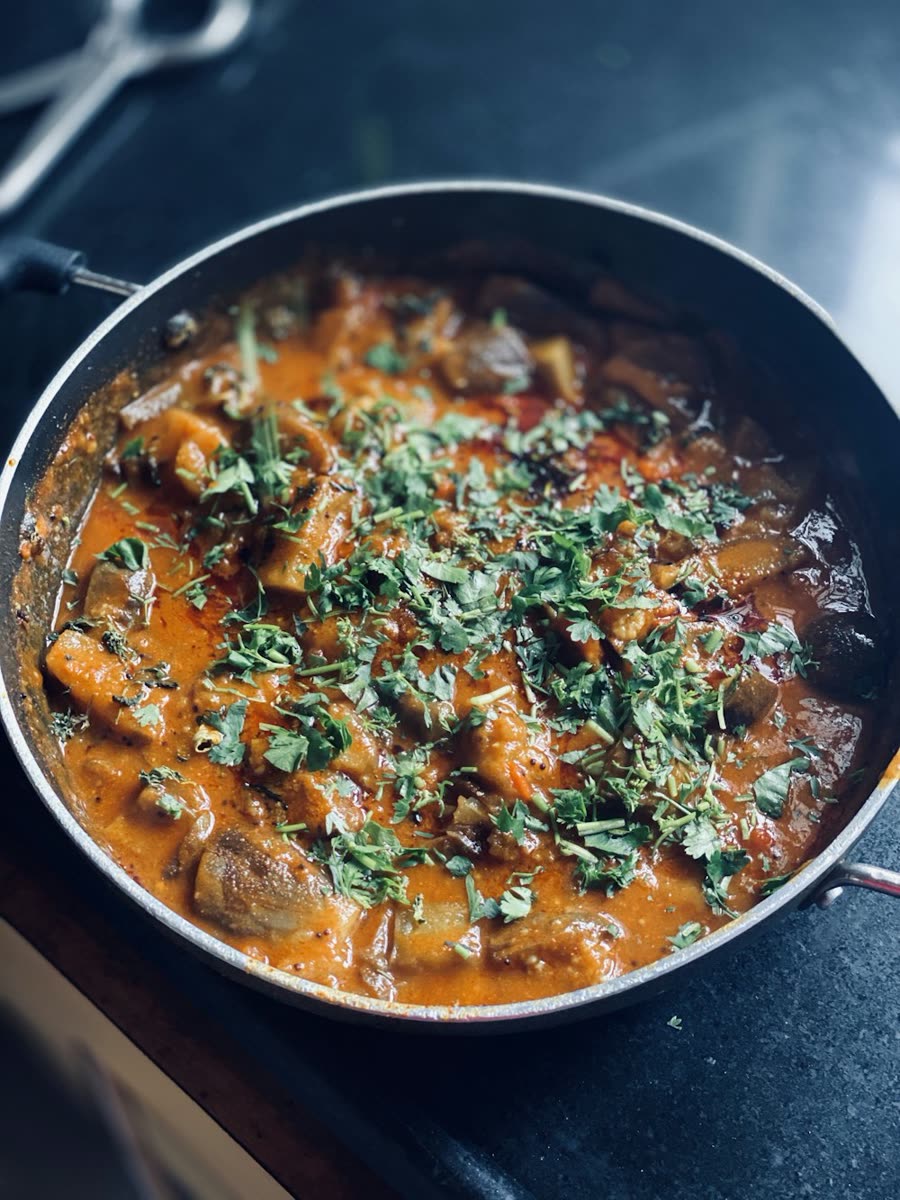 A pot of curry topped with fresh coriander